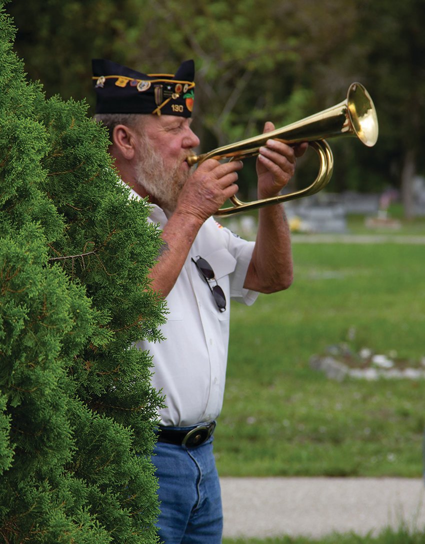Commander of the American Legion Bill Davis, plays Taps at the Ft. Denaud Cemetery.